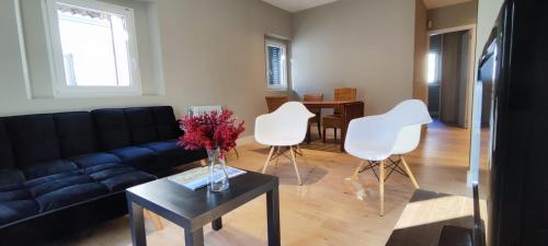 salon z kanapą i 2 białymi krzesłami w obiekcie La Casita de Sofia w mieście El Escorial