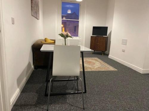 a table and a chair in a room with a couch at Bridgewater Flat in Bridgwater