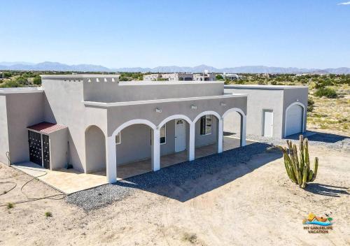a white house in the middle of the desert at Casa Desert Rose in Playa Hawaii
