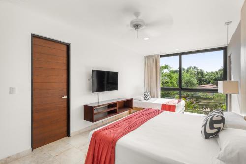 a bedroom with a large bed and a television at Downtown Condos Luxury in Playa del Carmen
