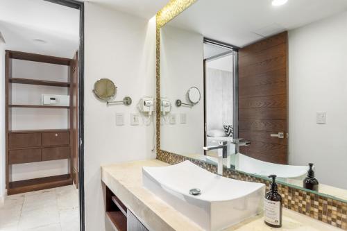 a bathroom with a sink and a mirror at Downtown Condos Luxury in Playa del Carmen
