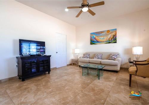 a living room with a couch and a flat screen tv at Casa Desert Rose in Playa Hawaii