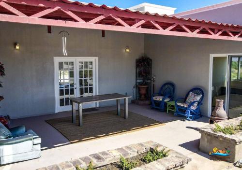 a patio with a table and chairs on a house at Casa Desert Rose in Playa Hawaii