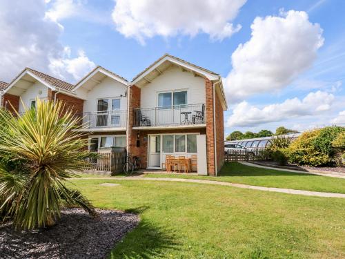 a large house with a lawn in front of it at 63 The Waterside Holiday Park in Lowestoft