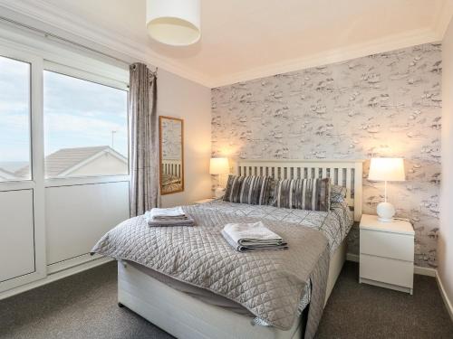 a bedroom with a bed and a large window at 63 The Waterside Holiday Park in Lowestoft