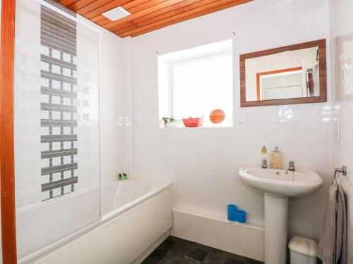 a white bathroom with a tub and a sink at 63 The Waterside Holiday Park in Lowestoft