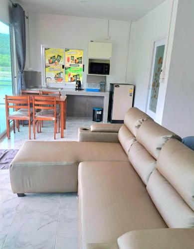 a living room with a couch and a table at บังกะโลบ้านสวนเอก Bungalow Baan Suan Aek in Ban Pang Chaphlung