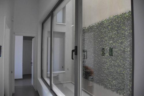 a glass door with a painting on a wall at Stylish Villa - Skylodge in Tolo