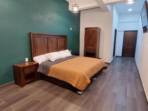 ein Schlafzimmer mit einem Bett und einer grünen Wand in der Unterkunft Hotel Cantera Jaguar in San Juan Teotihuacán
