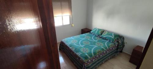 Kleines Zimmer mit einem Bett und einem Fenster in der Unterkunft Piso 3 dormitorios ideal para descansar in Jerez de la Frontera