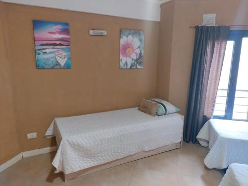 a bedroom with a bed and two pictures on the wall at departamentos lasserre in Río Grande