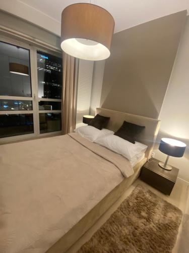 a bedroom with a large bed with a large window at Platinum Towers great view balcony 1 bedroom in Warsaw