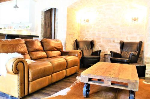 a living room with a brown couch and leather chairs at The Rustic Inn - Family friendly, Close to Fiesta Texas, SeaWorld, Riverwalk and more in Dominion