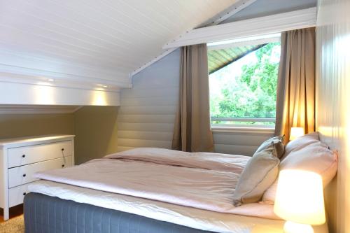 a bedroom with a large bed and a window at Villa Arboretet - Seaside villa with private pool & infrared sauna in the heart of Arboretet, Bergen in Bergen