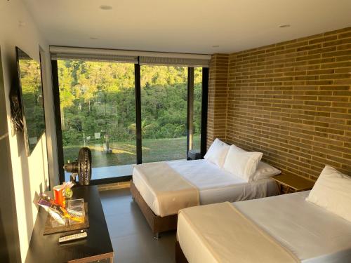 a hotel room with two beds and a large window at Hotel Mirador de la Esperanza in San Juan de Rioseco 