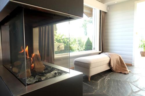 a living room with a fireplace and a couch at Villa Arboretet - Seaside villa with private pool & infrared sauna in the heart of Arboretet, Bergen in Bergen