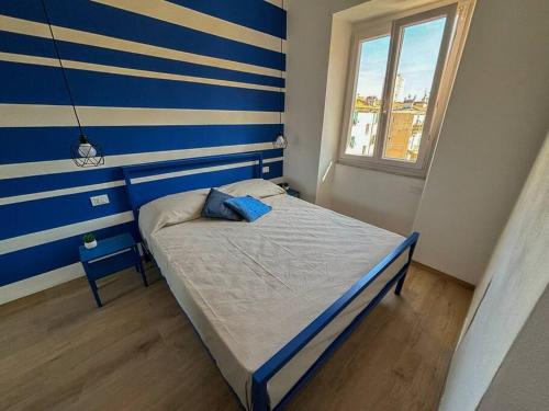 una piccola camera da letto con una parete a righe blu e bianche di La Casa di Chiara a La Spezia