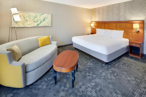 a hotel room with a bed and a couch at Courtyard Cleveland Beachwood in Beachwood