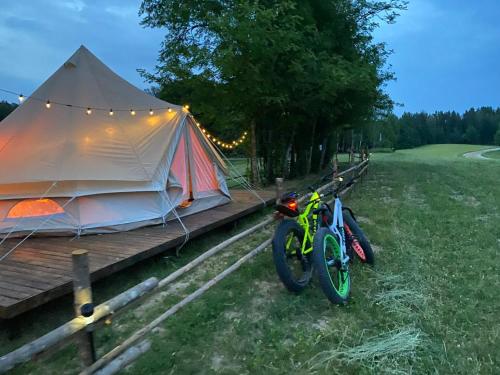 a tent with two bikes parked next to it at A Romantic & Luxurious stay in the nature of Karula National Park. in Ähijärve