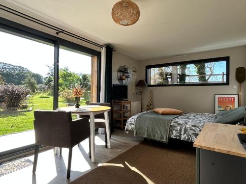 a bedroom with a bed and a table and a window at Le Cottage de l'Albâtre Gîte 2 pers jardin parking 6 kms Etretat Yport in La Forge