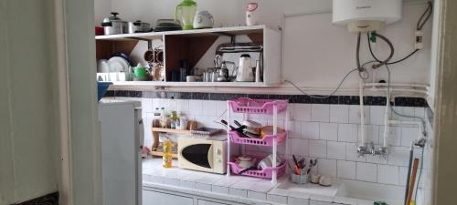 a kitchen with pink shelves and a microwave at appartement adam in Oujda