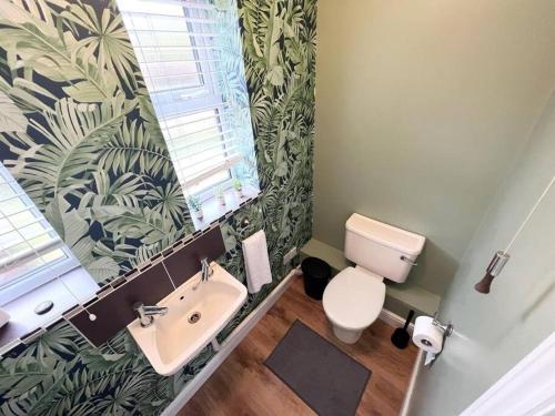 a bathroom with a white toilet and a sink at 4Bed Home MK in Shenley Brook End
