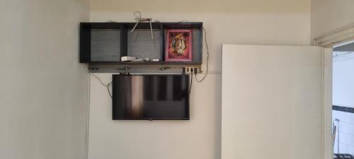 een televisie aan een muur naast een deur bij appartement adam in Oujda