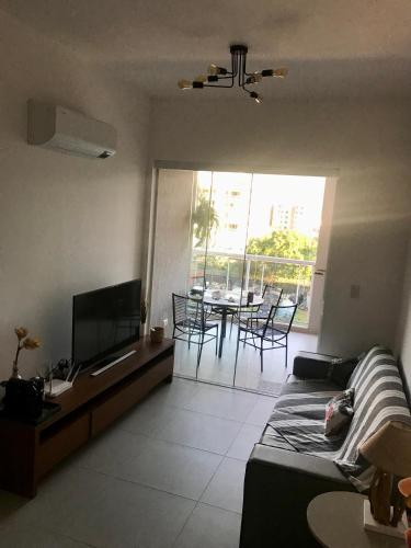 a living room with a couch and a tv and a table at Ubatuba Encantador in Ubatuba