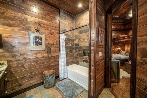 une salle de bain avec des murs en bois et une baignoire et une douche dans l'établissement Lasso The Moon, à Stephens Gap