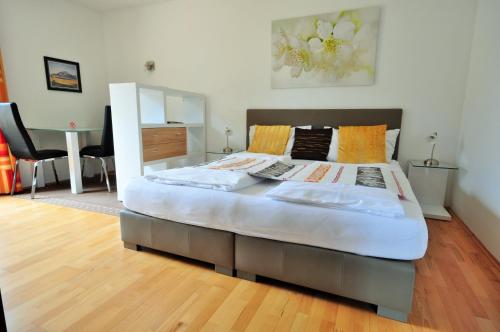ein großes Bett in einem Schlafzimmer mit Holzboden in der Unterkunft Appartements Peter in Sankt Kanzian am Klopeiner See