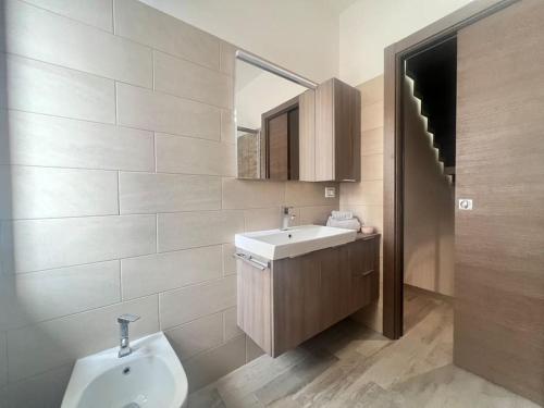 ein Badezimmer mit einem Waschbecken, einem WC und einem Spiegel in der Unterkunft Design Villa-Milano & Rho fiera in Sedriano