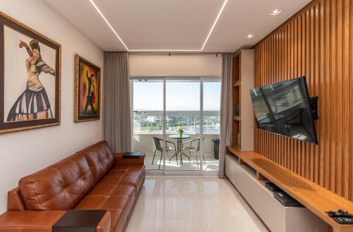 een woonkamer met een bank en een televisie bij Aptos modernos no Jardim Goiás FRP in Goiânia