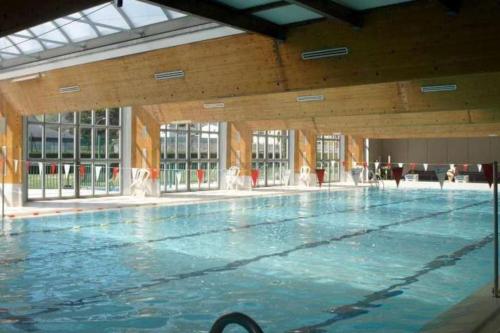 a large swimming pool with water in a building at Studio chez Cylène in Laruns