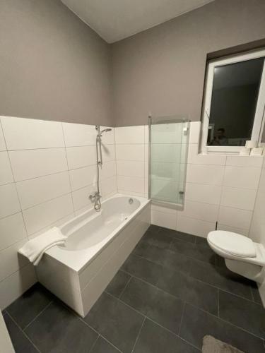 La salle de bains est pourvue d'une baignoire et de toilettes. dans l'établissement WEN BHF NEU & ZENTRAL in Weiden für bis zu 6 Personen, à Weiden