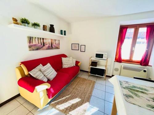 een woonkamer met een rode bank en een raam bij Luminoso in centro paese in Carona