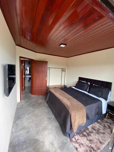 um quarto com uma cama grande e um tecto em madeira em Vista Bela em Bezerros