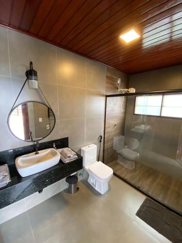een badkamer met een wastafel, een toilet en een spiegel bij Vista Bela in Bezerros