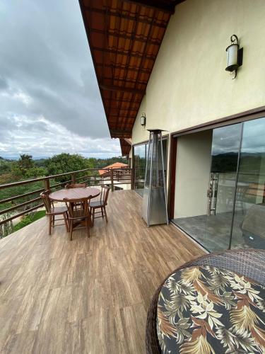 eine Terrasse mit einem Tisch und Stühlen auf einer Terrasse in der Unterkunft Vista Bela in Bezerros