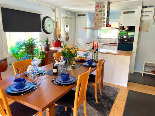 comedor con mesa de madera y sillas en Lovely cottage by the south coast, en Trelleborg
