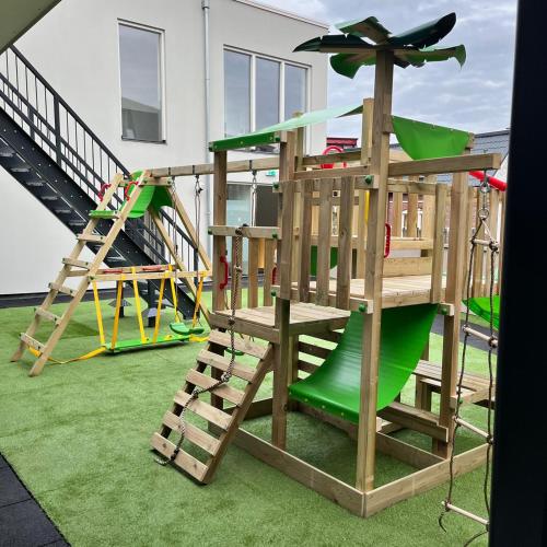a playground with two swings and a slide at The Residence Apeldoorn in Apeldoorn