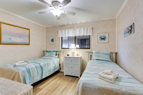 a bedroom with two beds and a ceiling fan at Hilton Head Condo with Balcony and Pool, Walk to Beach in Hilton Head Island
