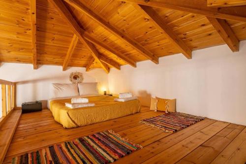 - une chambre avec un lit dans un dortoir doté de parquet dans l'établissement Pomogna house, à Pemónia