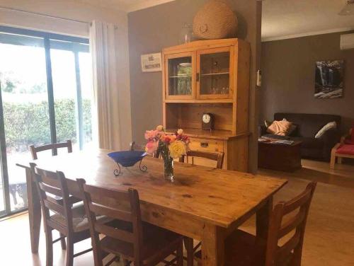 a dining room table with a vase of flowers on it at Peaks Trail Rest Dunkeld in Dunkeld