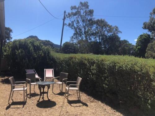 a group of chairs and a table in front of a hedge at Peaks Trail Rest Dunkeld in Dunkeld