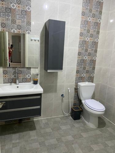 a bathroom with a toilet and a sink and a mirror at Faima in Douz