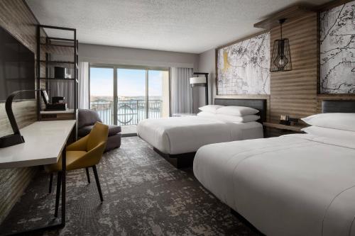 a hotel room with two beds and a desk at Marriott Indianapolis North in Indianapolis