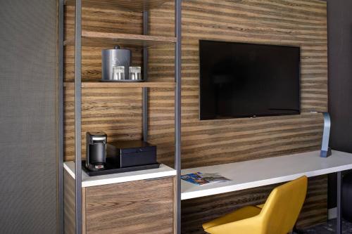 a room with a desk with a television and a chair at Marriott Indianapolis North in Indianapolis