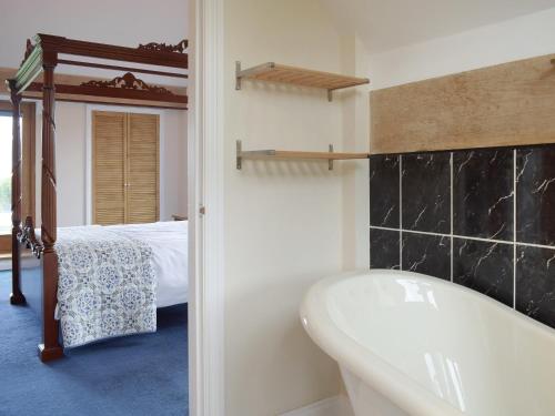 a bathroom with a bath tub and a bed at The Grange in Dinmore