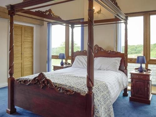 a bedroom with a large canopy bed with white sheets at The Grange in Dinmore