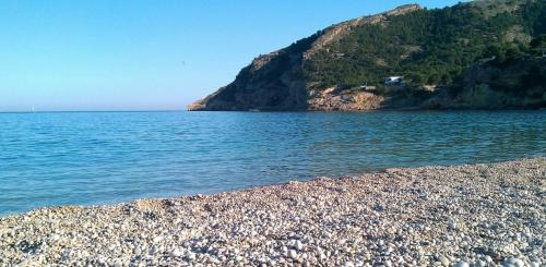 a rocky beach with a large body of water at Apartamento Alfaz Del Sol in L’Alfàs del Pi